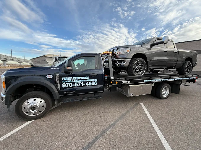 First Response Towing flatbed hauling a lifted pickup truck