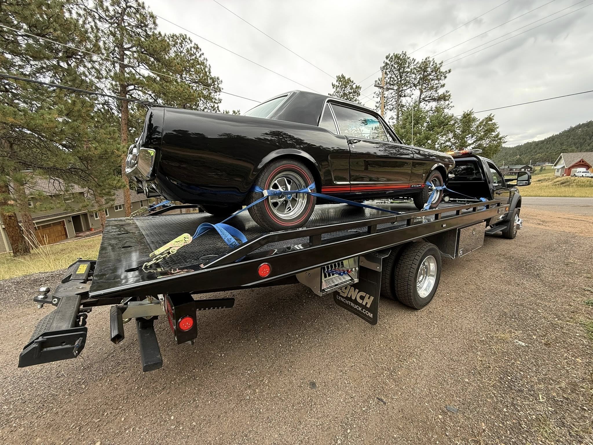 Black classic pickup truck secured on a flatbed trailer