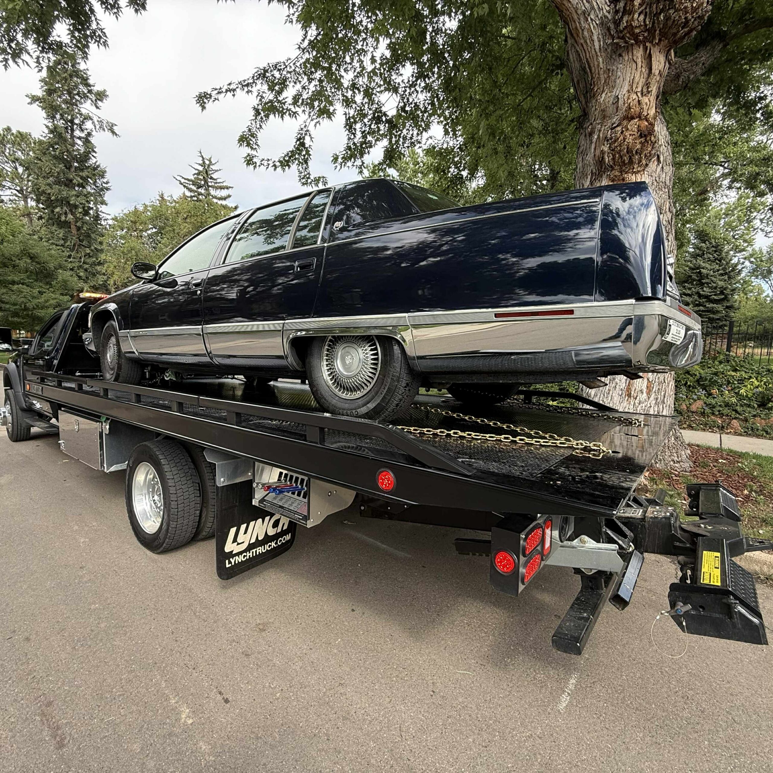 Classic dark blue Cadillac loaded on a First Response Towing flatbed