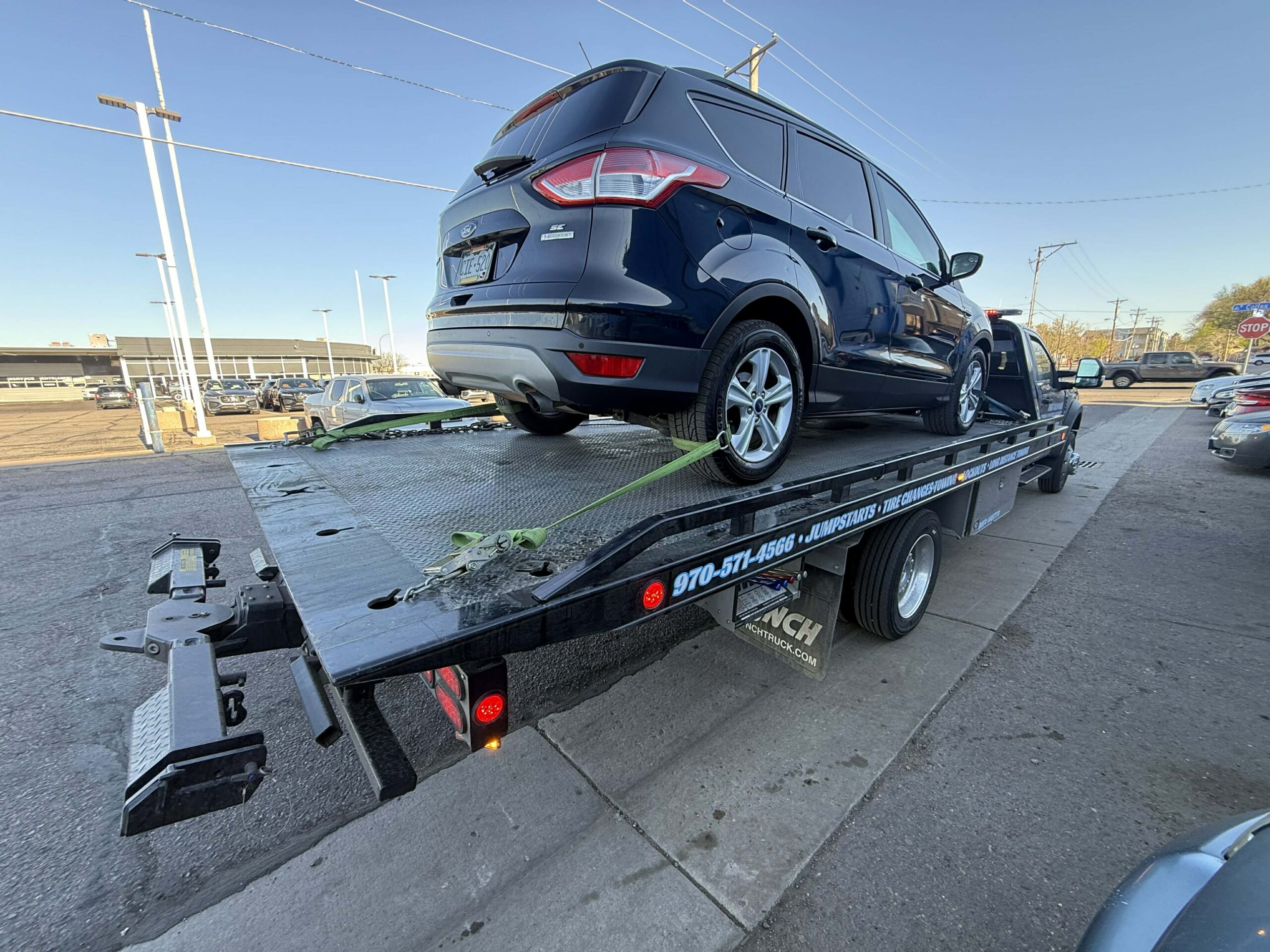 SUV loaded on a tilted flatbed tow truck ready for transport