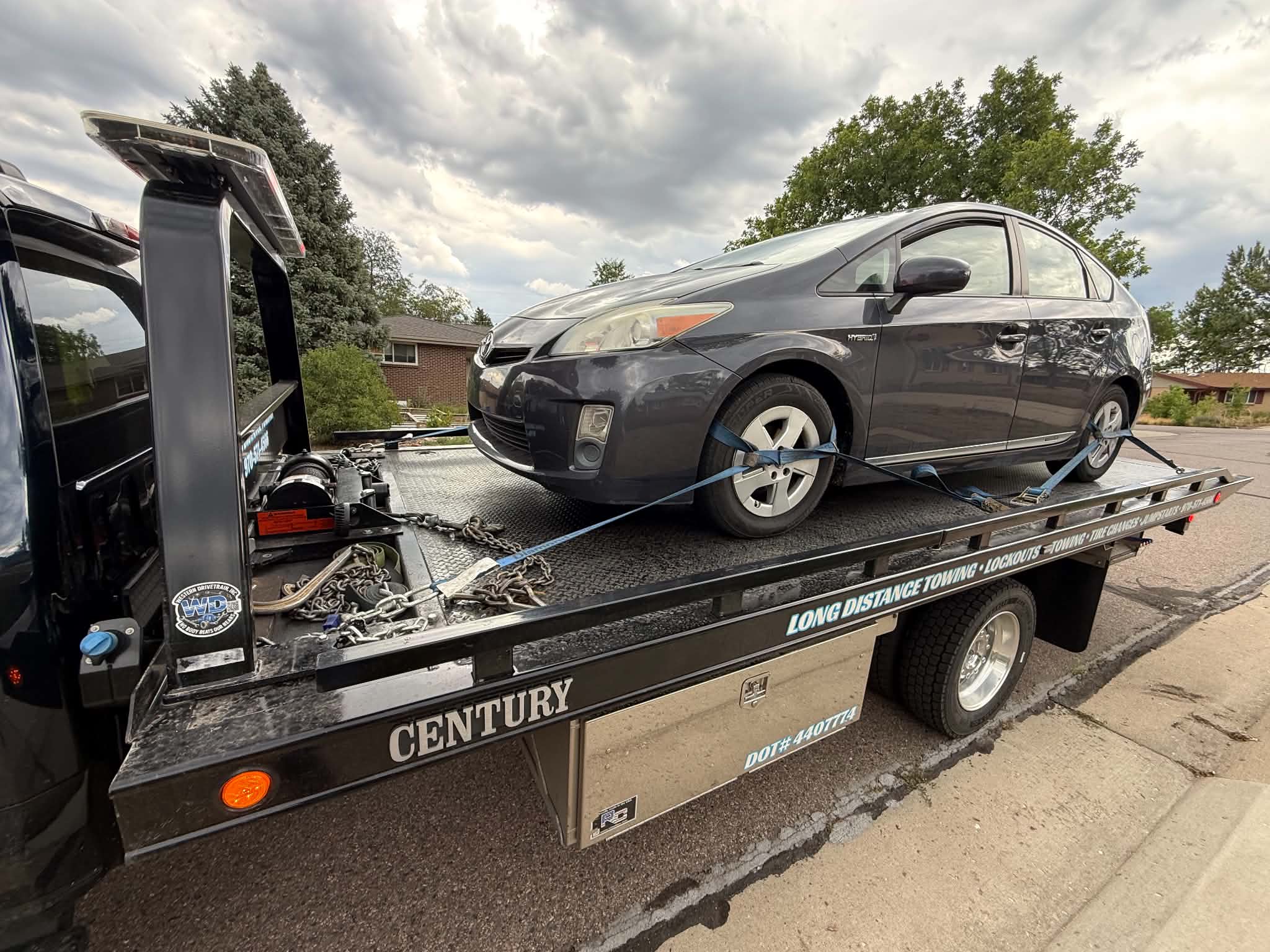 Hybrid sedan secured on a flatbed tow truck